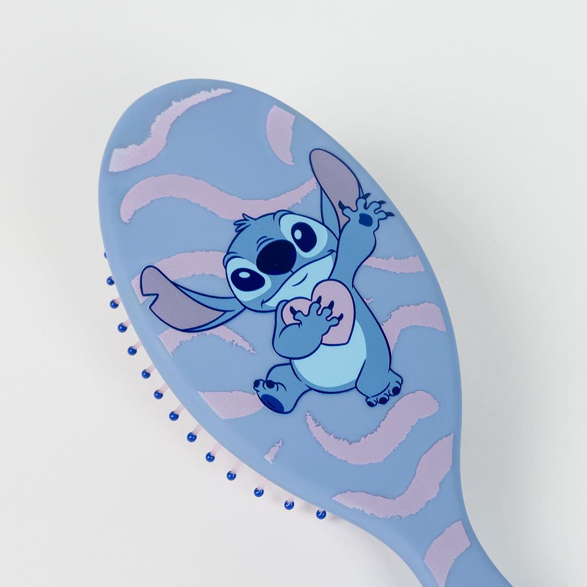 Blue hairbrush with Stitch character design and pink wave pattern on the back.