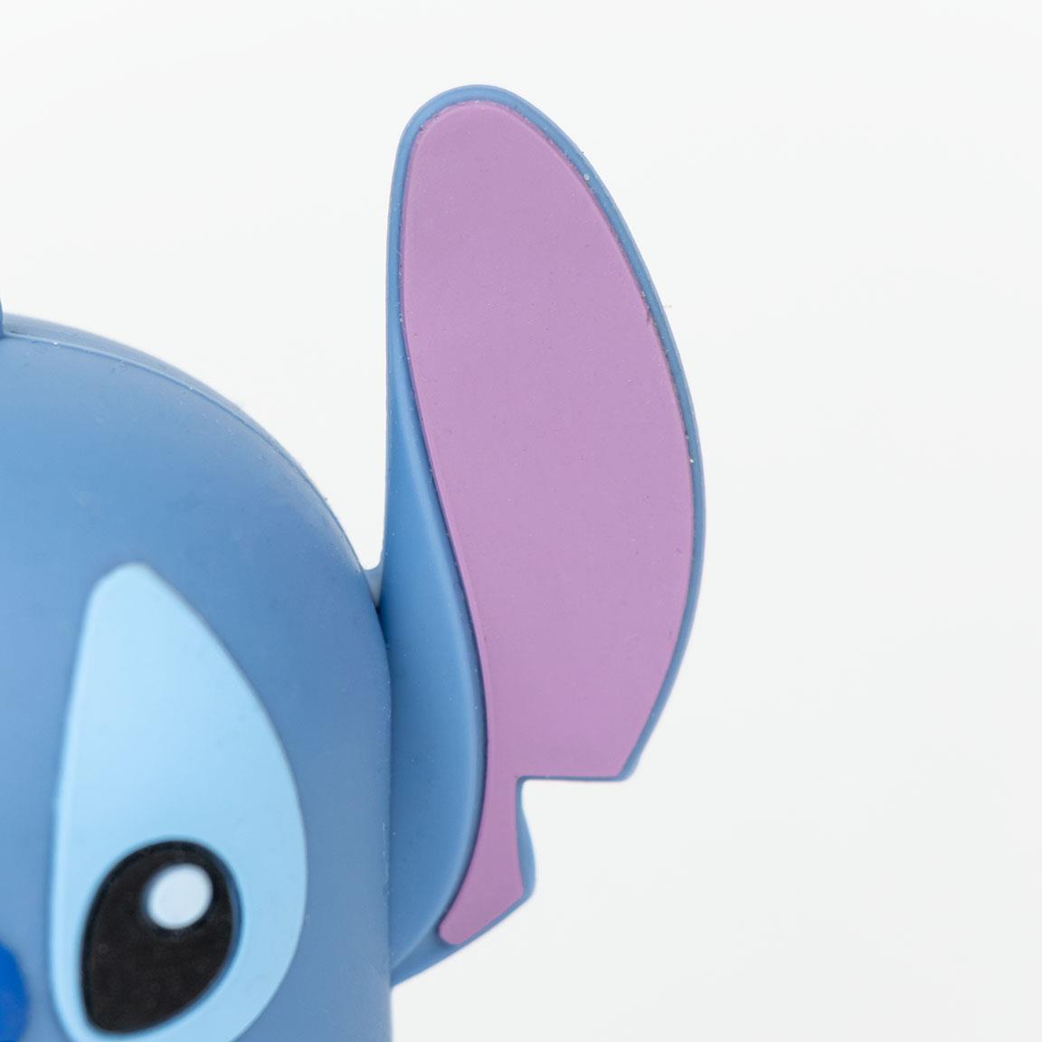 Close-up of a blue toy figure with large purple ear and black eye, featuring a minimalist design.