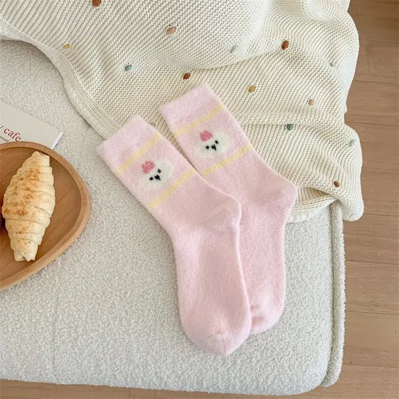 Kósýsokkar - hvítir og bleikir with cartoon head design, pink and white striped, cozy Australian velvet socks on a comfy home setting.