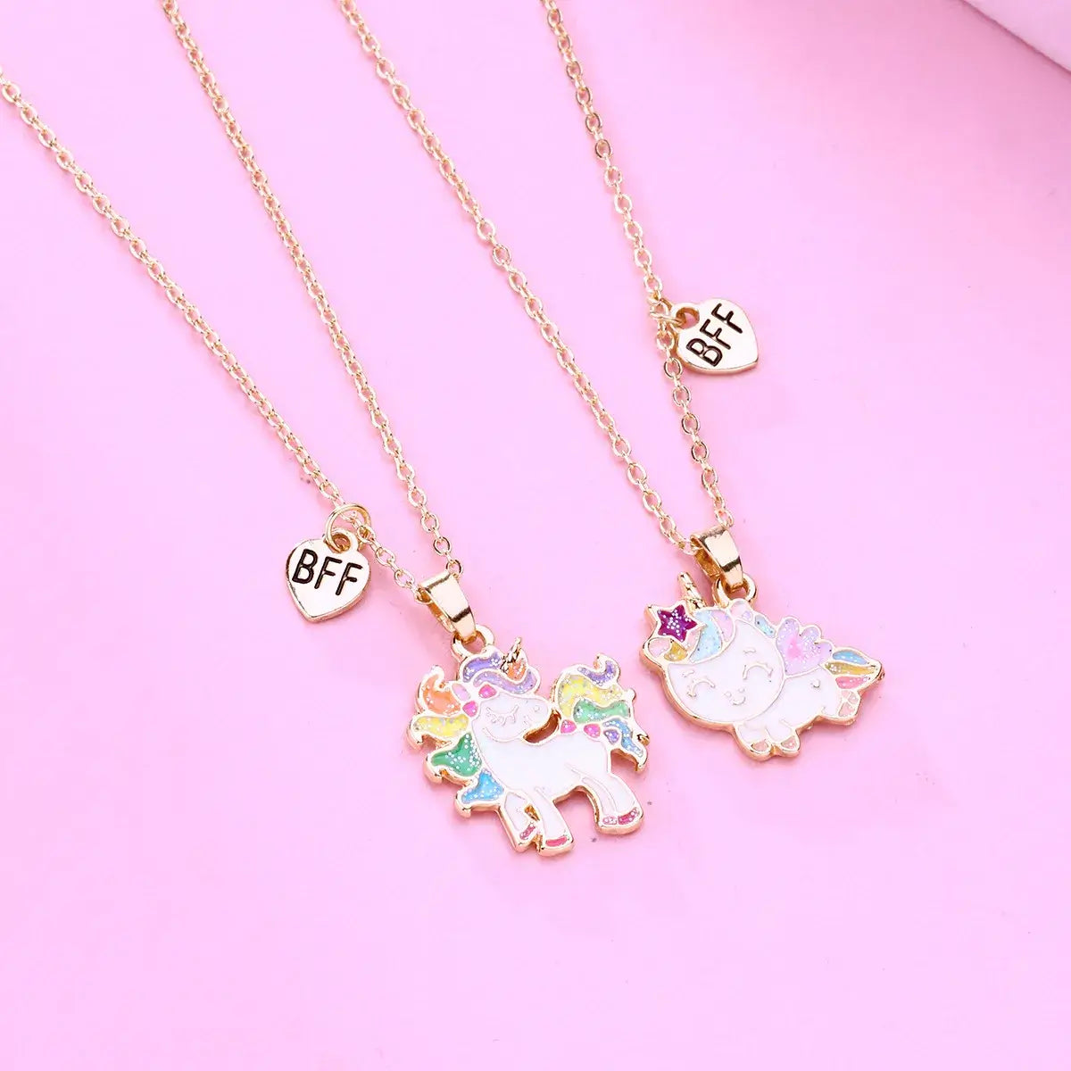 Hálsmen - einhyrningar - BFF; two unicorn necklaces with BFF charms on pink background.