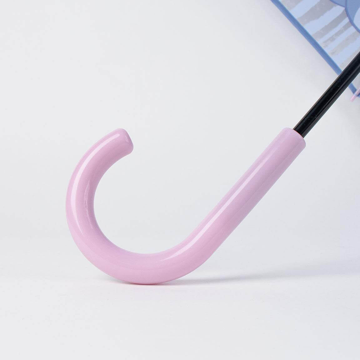 Close-up of a pink umbrella handle, part of the Regnhlíf-Stitch design, featuring durable construction and stylish pastel color.