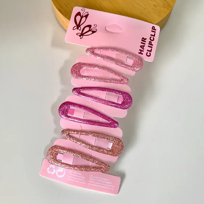 Hárspennur - Glimmer 6 stk on a display board showing pink glitter hair clips for girls, available for ages 6-12.