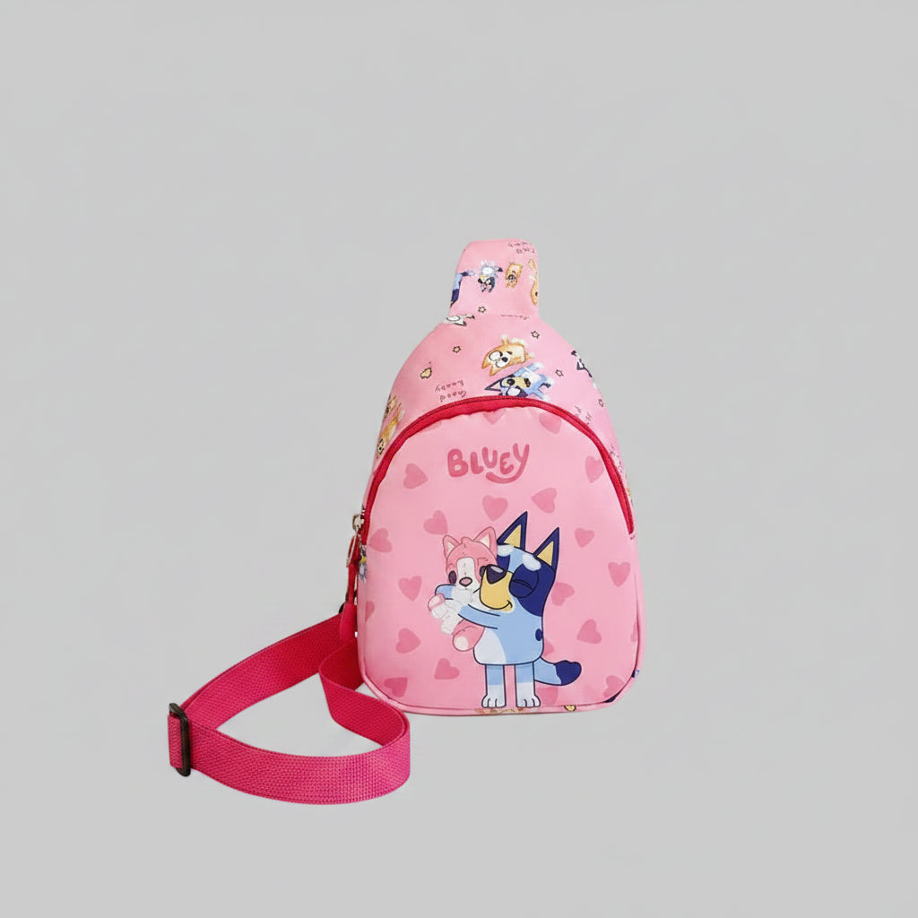 Pink sling bag with cartoon design on a white surface with books and a box in the background