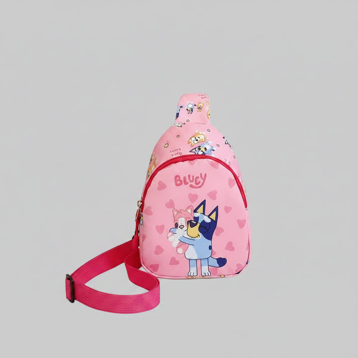 Pink sling bag with cartoon design on a white surface with books and a box in the background